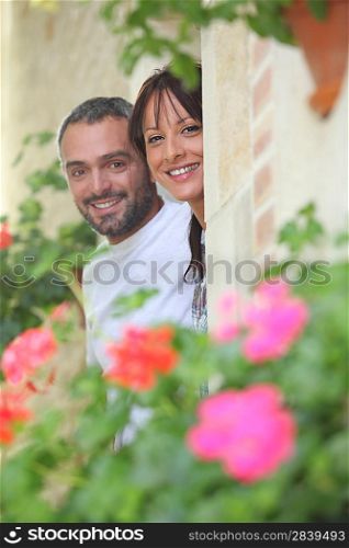 Couple hiding by a stone wall