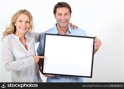 Couple holding a blank board