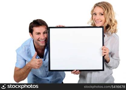 Couple holding a blank sign