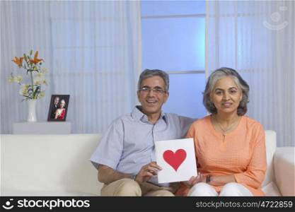 Couple holding a card with a heart