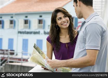 Couple holding a map and smiling