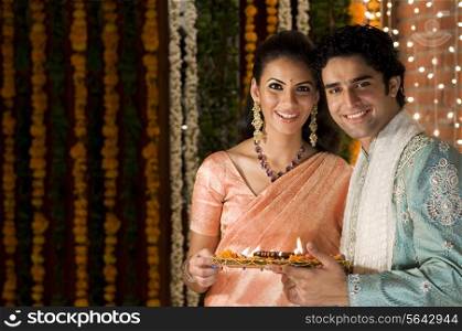 Couple holding a tray of diyas