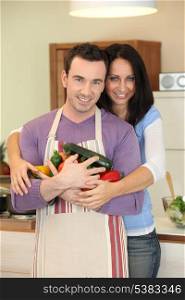 Couple holding a variety of vegetables