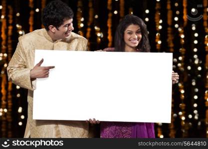 Couple holding a white board