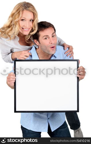 Couple holding blank message board