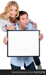 Couple holding blank message board