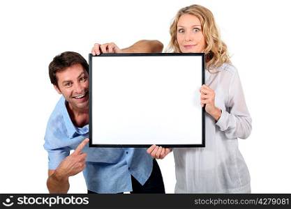 Couple holding blank picture frame