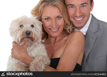 Couple holding dog.
