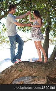 Couple holding each others hands on a tree branch