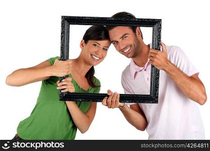 Couple holding empty art frame