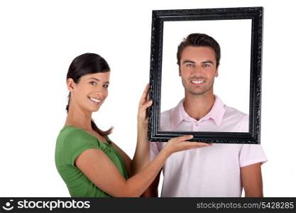 Couple holding empty picture frame