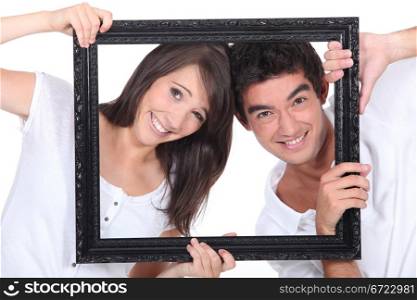Couple holding empty picture frame