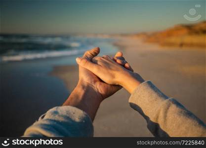 Couple holding hand on the beach