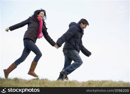 Couple Holding Hands And Running In The Park