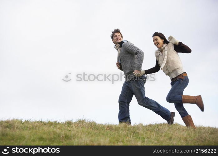 Couple Holding Hands And Running In The Park