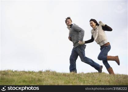 Couple Holding Hands And Running In The Park