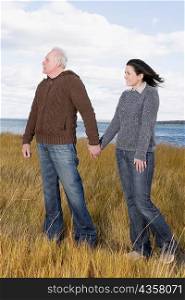 Couple holding hands and standing on the beach