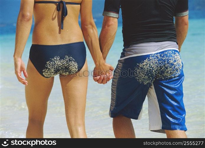 Couple holding hands at the beach (selective focus)