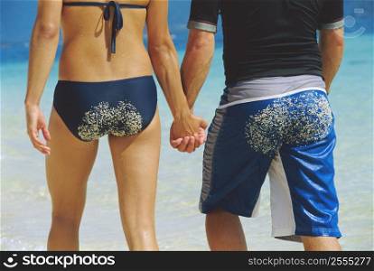 Couple holding hands at the beach (selective focus)