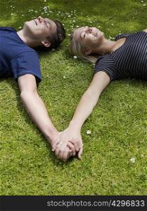 Couple holding hands in grass