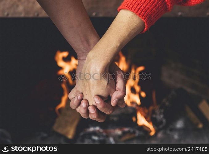 couple holding hands near fireplace