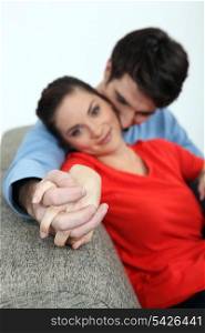 Couple holding hands on a sofa
