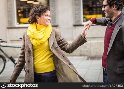 Couple holding hands on city street