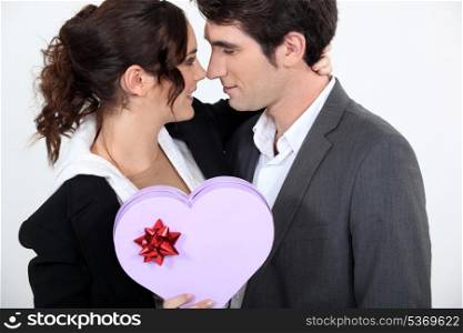 Couple holding heart-shaped box