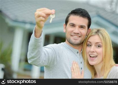 Couple holding keys to their new house