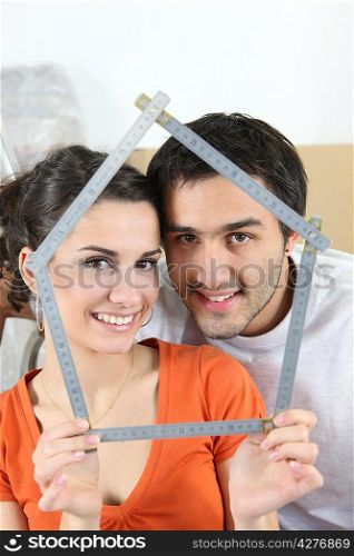 Couple holding measuring device