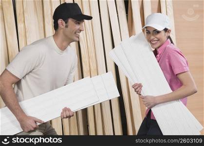 Couple holding sheets of plywood