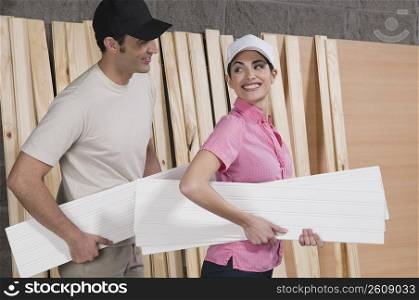 Couple holding sheets of plywood