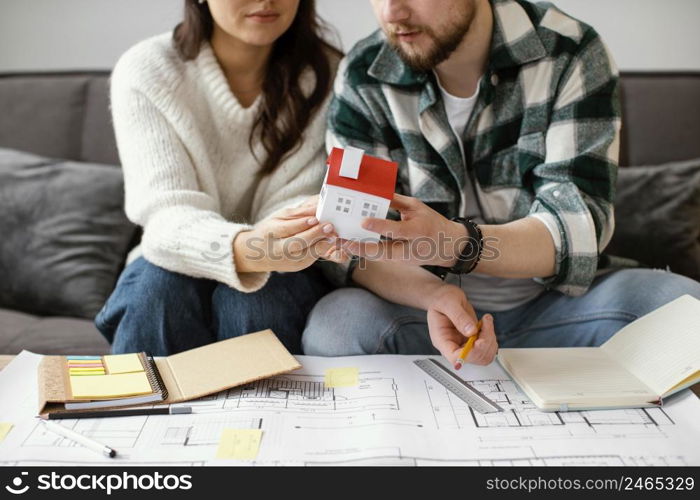 couple holding small house close up