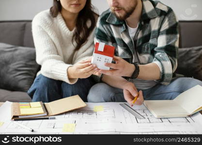 couple holding small house close up