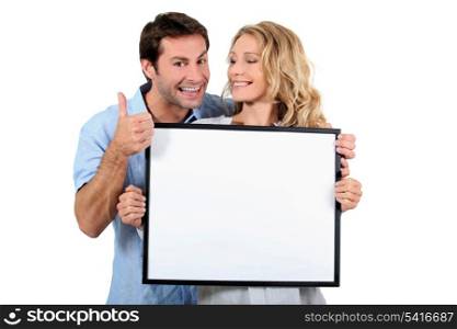 Couple holding white board