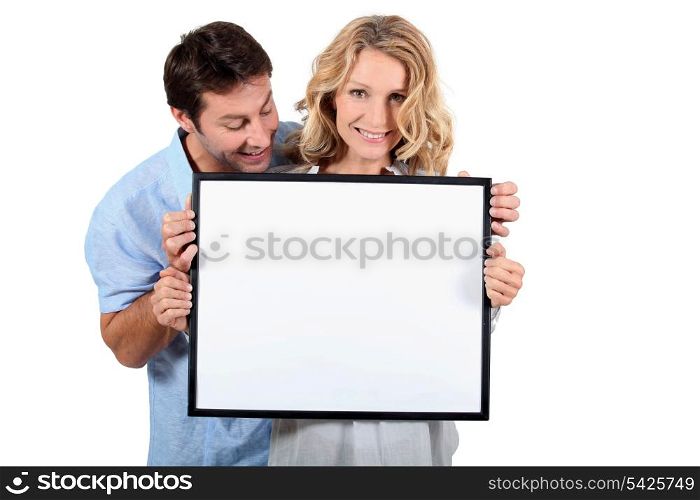 Couple holding white board