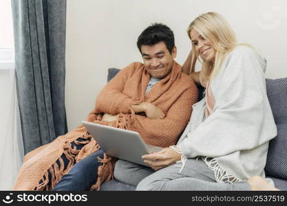 couple home together using laptop couch