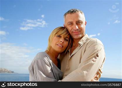 Couple hugging against a blue sky
