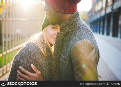 Couple hugging beside steel fence