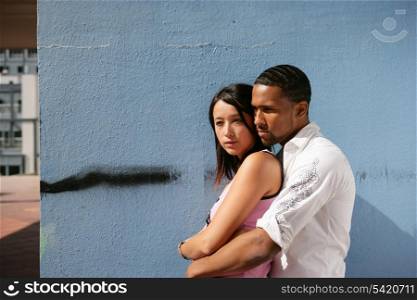 Couple hugging by wall