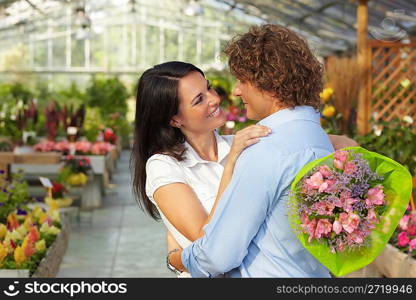 couple hugging in flower nursery