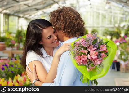 couple hugging in flower nursery