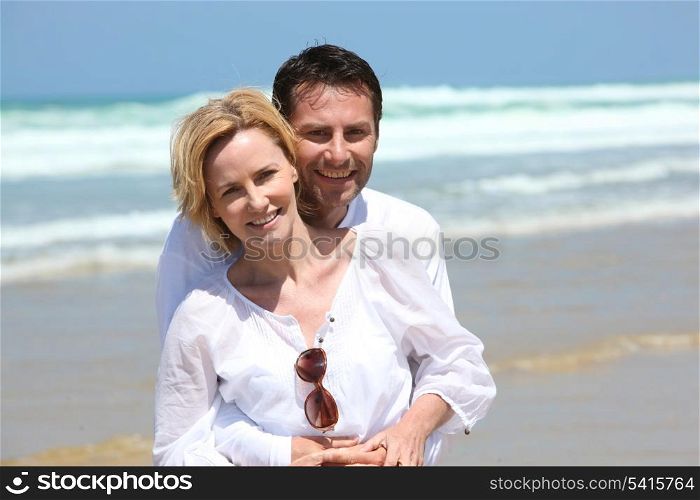 Couple hugging in front of the surf