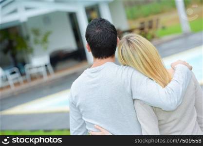 Couple hugging in front of their new house