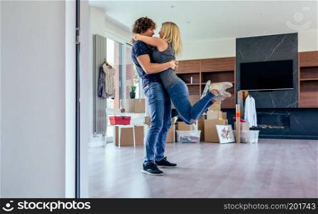 Couple hugging in the living room of their new house. Couple hugging in the living room