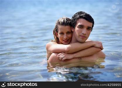 Couple hugging in the water