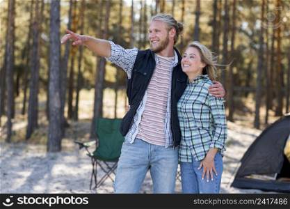 couple hugging man pointing his finger