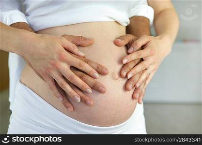 Couple hugging pregnant belly