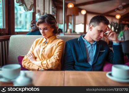 Couple in a bad mood sitting in restaurant. Man and woman relationship. Couple in a bad mood sitting in restaurant