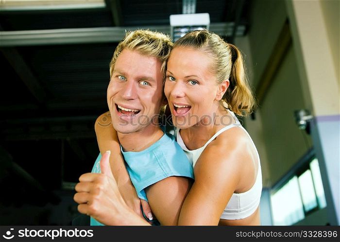 Couple in a gym having a lot of fun and success in their training